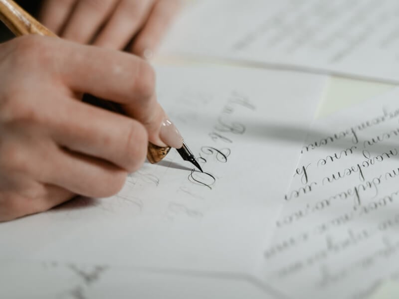 A woman writing in calligraphy